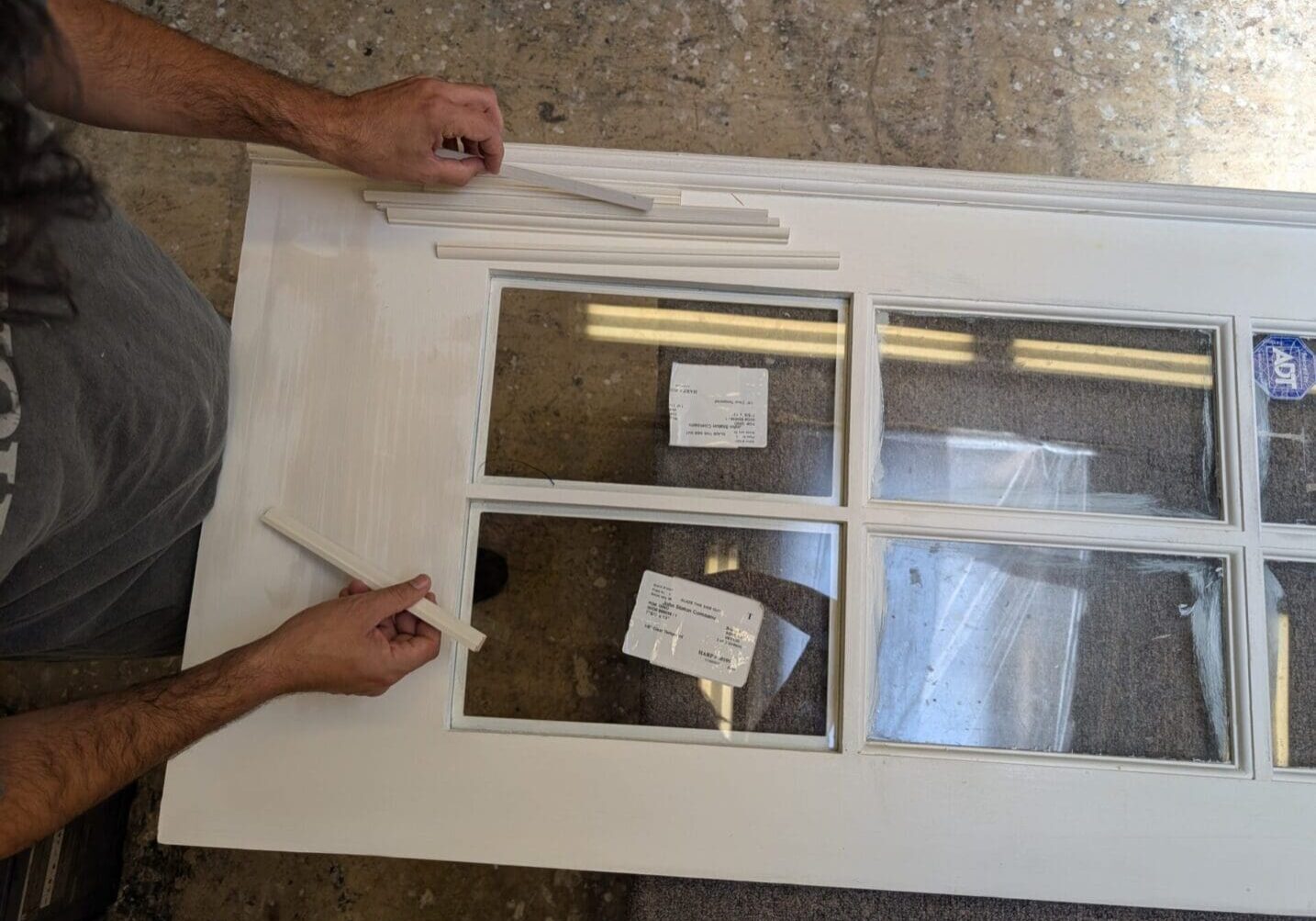 Skilled craftsman fitting custom wood windows in a residential home.